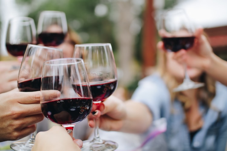 Amigos comemorando aniversário e se deliciando dos benefícios do vinho