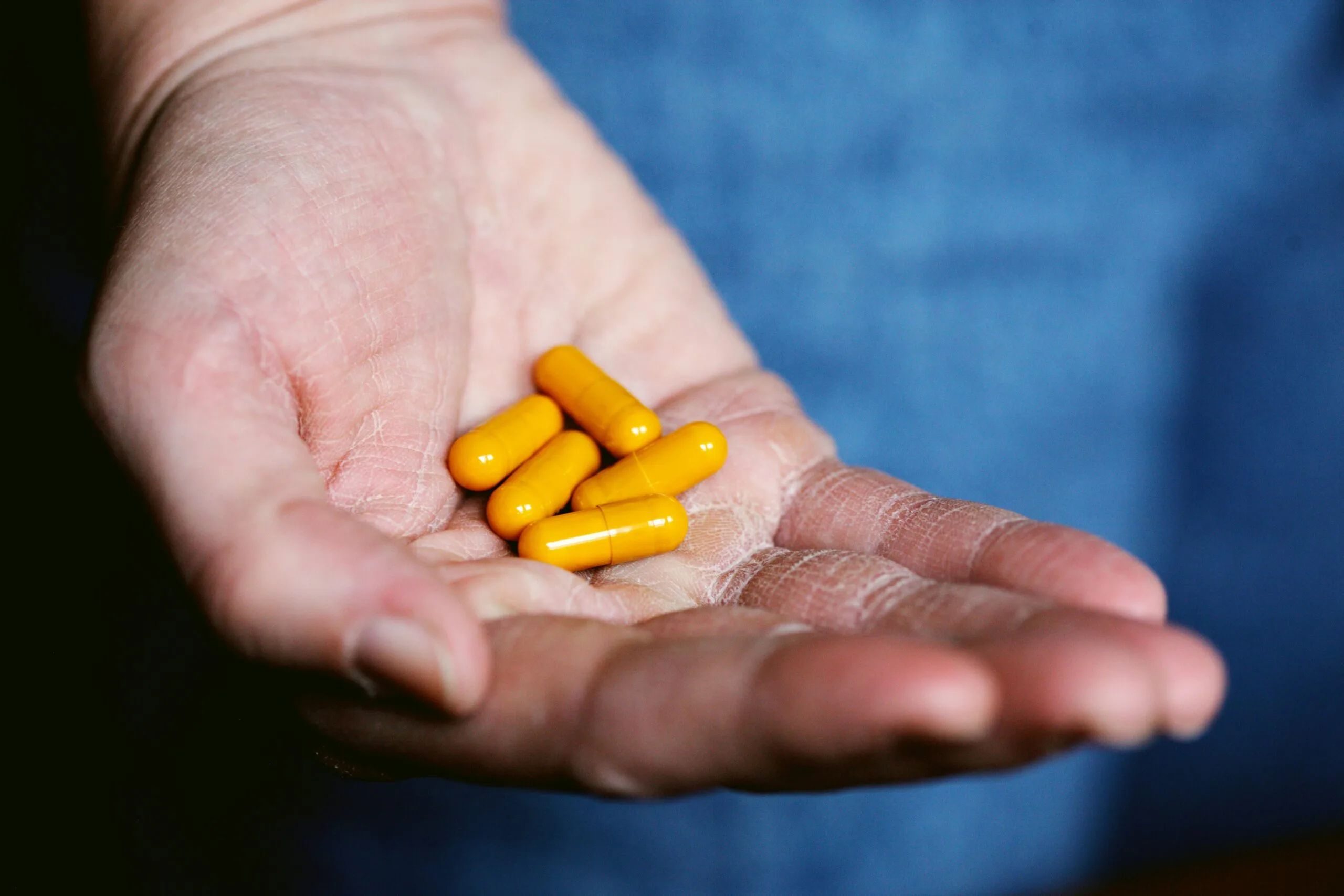 yellow medication pill - misoprostol, Citrato de Tamoxifeno - on persons hand