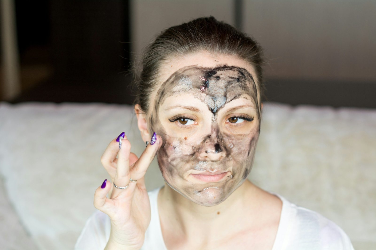 a woman with a face mask on holding her hand up to her face - acne severa