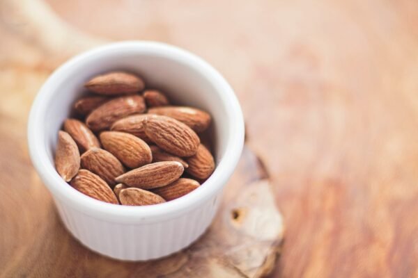 shallow focus photography of almonds (amêndoas) in white ceramic bowl